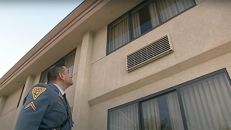 Investigator examining motel sidewalk